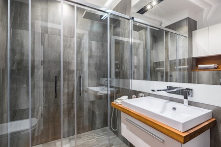 Perfect bathroom with gray tiling, shower, cabinet basin and mirrorの写真素材