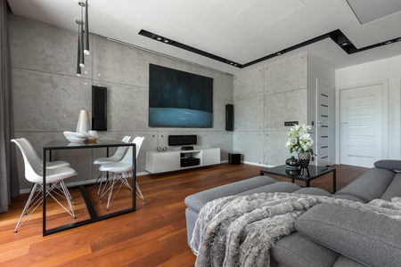 Home interior with dining table, sofa, cement wall and modern paintingの写真素材