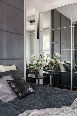 Luxurious bedroom with mirror, bed and side tableの写真素材