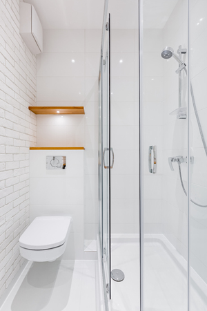 White bathroom with modern brick tiles, toilet and showerの写真素材