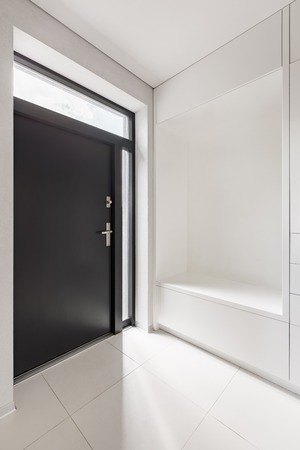 Elegant home interior with white entryway and black doorの写真素材