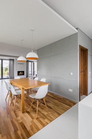 Modern home with wooden dining table and white chairsの写真素材