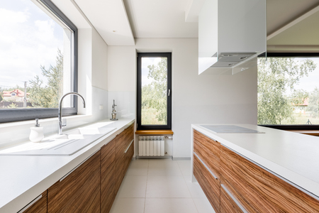 Modern kitchen with white countertop, big window and islandの写真素材