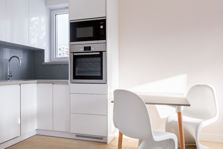 White kitchen with table and two modern chairsの写真素材