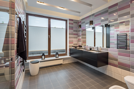 Spacious bathroom with brick tiles, black cabinet and two sinksの写真素材