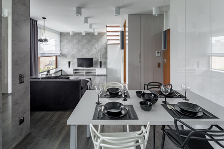 Modern apartment in gray and white with white dining tableの写真素材