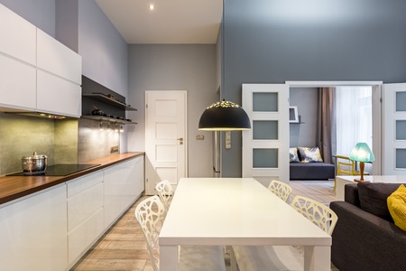 Modern kitchen with white dining table and openwork chairsの写真素材