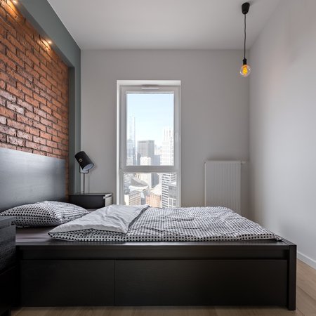 Loft bedroom with double bed, window and brick wallの写真素材