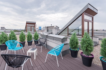 Beautiful rooftop terrace with modern black and turquoise chairsの写真素材