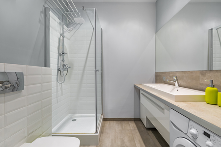 Modern bathroom with shower, countertop basin, washer and big mirrorの写真素材