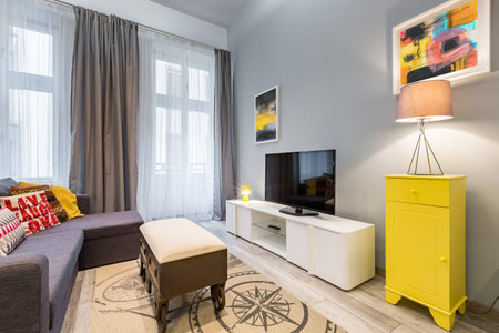 Contemporary living room with tv, wheel coffee table and yellow cabinet