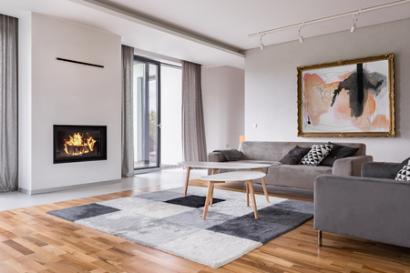 Modern living room with fireplace, sofa, balcony and pattern carpetの写真素材