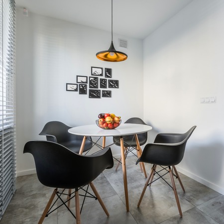 White home interior with lamp, modern round table and black chairsの写真素材