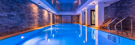 Luxurious villa swimming pool with brick walls, evening view, panoramaの写真素材