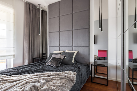 Fancy bedroom with double bed, mirror and window curtainsの写真素材