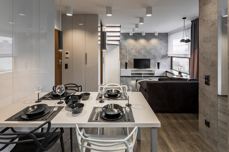 Modern apartment with white table and black dinnerwareの写真素材