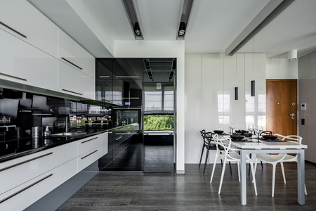 Contemporary kitchen in black and white with dining tableの写真素材