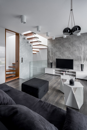 Elegant living room with couch, tv, table and staircaseの写真素材
