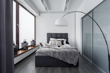 Modern bedroom with floor lamp, wardrobe and double bedの写真素材