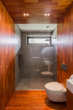 Wooden bathroom with walk in shower and toiletの写真素材