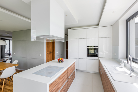Luxurious white kitchen with island and wooden cupboardsの写真素材