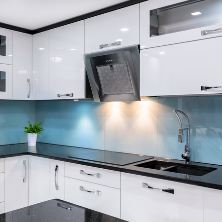 Modern kitchen with white furniture and black worktopの写真素材