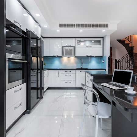 Modern and functional kitchen interior with black working space and white furnitureの写真素材