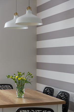 Dining room with wooden table and striped painted wallの写真素材