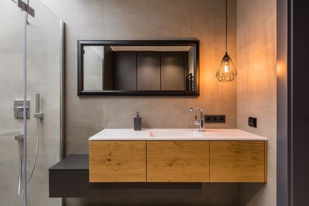 Integral countertop sink on wooden cabinets in contemporary bathroomの写真素材