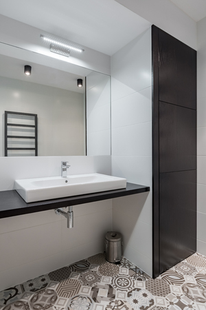 Black and white bathroom with countertop basin and mirrorの写真素材
