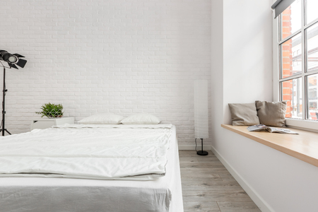 White brick wall in loft bedroom with big windowの写真素材