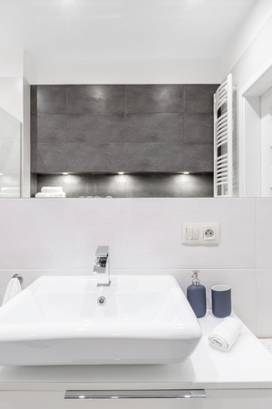 White sink and mirror in modern bathroom with concrete tilesの写真素材