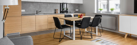 Panoramic view of kitchen with modern table and black chairsの写真素材