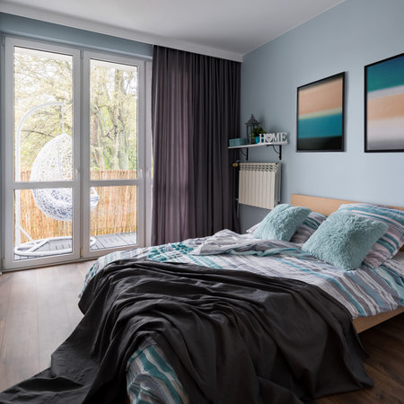 Simple bedroom with double bed and wall paintings