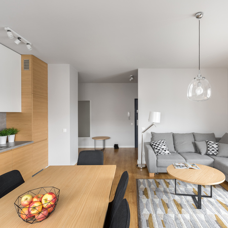 Square photo of modern open space dining room with table and gray sofaの写真素材