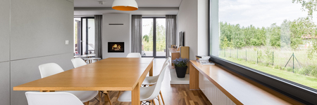 Panoramic view of dining room with wooden table, chairs and big windowの写真素材
