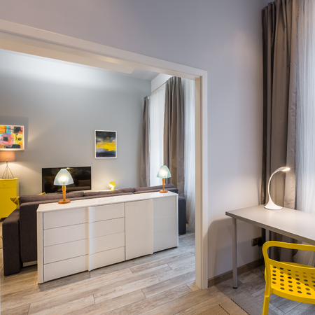 Home interior with simple desk, yellow chair and white dresserの写真素材