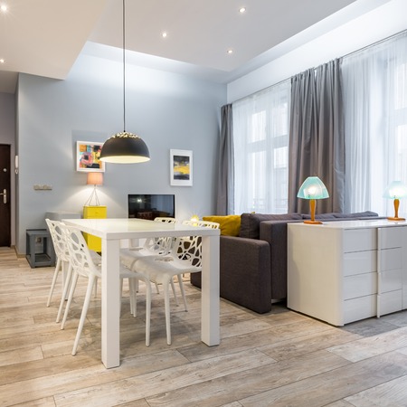 Modern studio flat with white table and dresserの写真素材