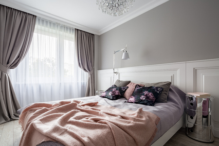 Pastel bedroom with double bed and decorative window curtainsの写真素材