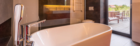 Luxurious bathroom with stylish bathtub and big window, panorama