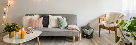 Panorama of sofa, coffee table and wicker chair in scandinavian style living roomの写真素材