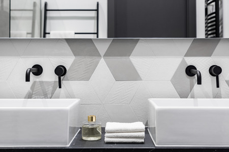 Contemporary designed bathroom with two washbasins with black faucetsの写真素材