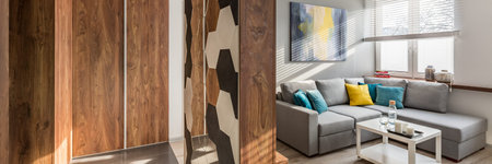 Panorama of new home interior with wooden entry room and bright living room