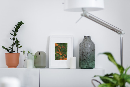 Scandinavian home interior with decorative accessories standing on a white cabinetの写真素材