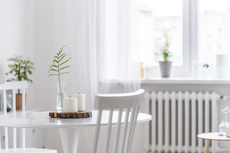 Cozy home interior with white, round table and wooden chairsの写真素材