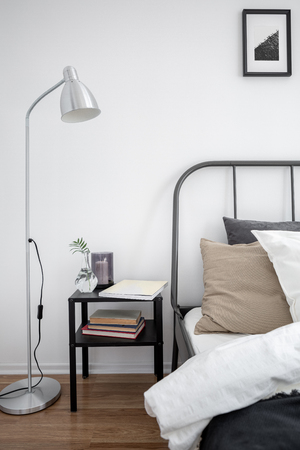 Simple bedroom interior with bed, lamp and nightstandの写真素材