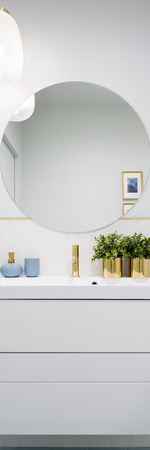 Vertical panorama of bathroom with round mirror and white cabinet with drawersの写真素材
