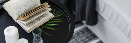 Open book lying on a black, metal coffee table, panoramaの写真素材