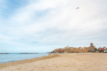 View of Termoli city in Italy with wide beach and calm sea and paraglider flying above