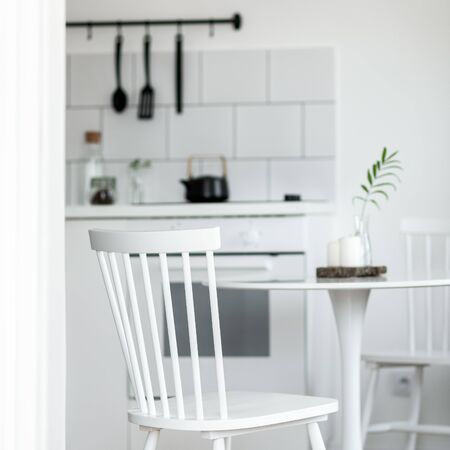 Simple wooden white chair and small round table in the kitchenの写真素材